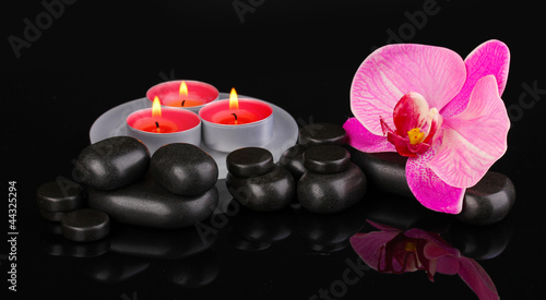 Plakat na papierze fotorealistycznym Kamienie spa z kwiatem orchidei i świece odizolowane na czarno