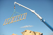 A crane lifting a wood structure.