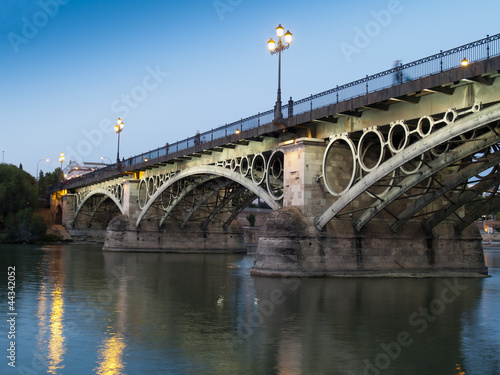 Fotoboard na płycie Most triana, najstarszy most Sewilli o zmierzchu