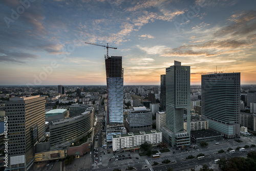 Board z aluminiowym obramowaniem Panoramiczny widok miasta warszawy podczas zachodu słońca.