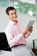 © Tyler Olson - Business Executive Holding Digital Tablet
