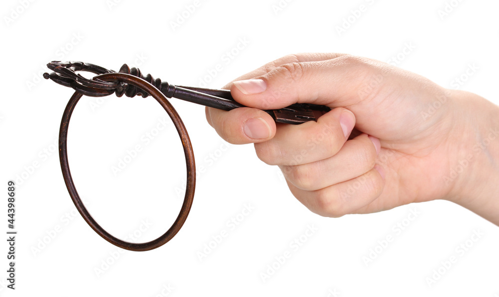woman's hand holding an antique key on white background