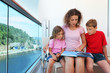 © Pavel Losevsky - Mother, daughter and son carefully review book on cruise liner
