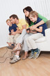 © Andrey Popov - Young family playing videogames