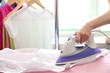 © Africa Studio - Woman hand ironing a shirt, on cloth background