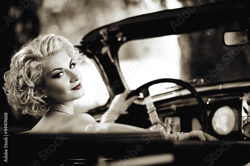 Fototapeta na wymiar Retro woman behind steering wheel