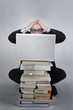 © oconairekat - Verzweifelter Mann hinter Laptop Bücherstapel