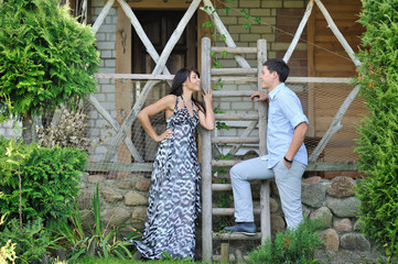 Young beautiful couple standing near a ladder in a village and s