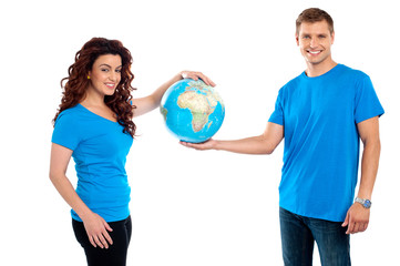 Attractive young couple holding a globe together