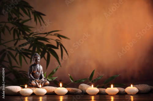 Fototapeta na wymiar Buddha with burning candle and bamboo