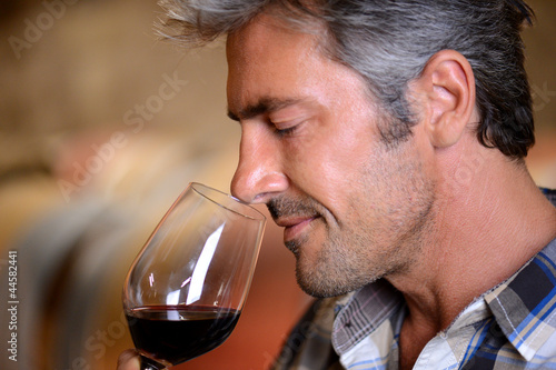 Fotografía Closeup on winemaker smelling red wine in glass