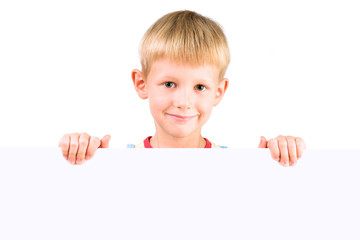 handsome boy 5-6 years old holding blank poster isolated over wh