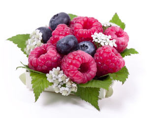 Wall Mural - Ripe raspberry and blueberries with green leaf