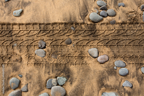 Naklejka na szybę car tire footpring in a sand stones beach
