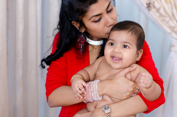 Mother kissing baby girl