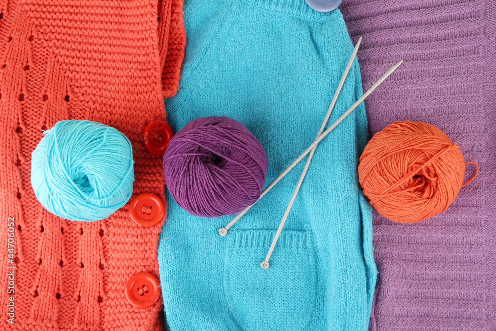 colorful wool sweaters and balls of wool close-up