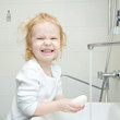 © Vitalinka - smiling girl washing hands and face with soap in the bathroom
