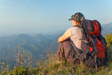 young woman in the mountains at sunset