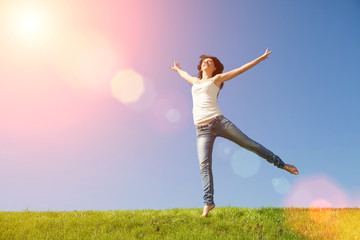 pretty young woman jumping on green grass