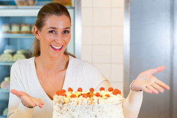 Bäckerin oder Konditorin mit einer Torte