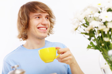 Young happy man drinking tea