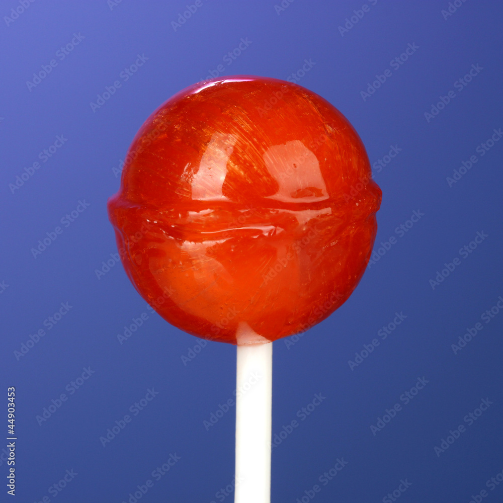 Sweet and tasty lollipop on bright blue background close-up