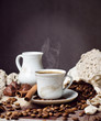 a cup of aromatic hot coffee, coffee beans, milk jug & cinnamon