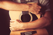 © flowerstock - hands holding an acoustic guitar