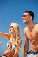 Poster - happy couple in sunglasses on the beach