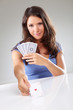 Woman playing cards with ace of hearts in her hand