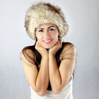 Uśmiechnięta piękna kobieta w czapce chroniącej przed zimą