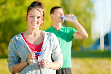 Man and woman drinking from bottle