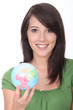 © auremar - Brunette holding miniature globe