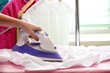 © Africa Studio - Woman hand ironing a shirt, on cloth background