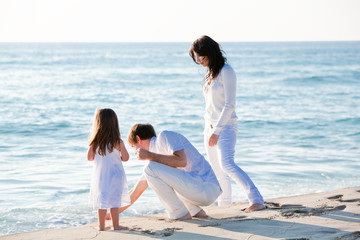 glückliche junge familie mit kleiner Tochter am Strand am wasse