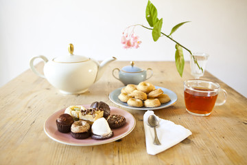 Wall Mural - plates of pastries and biscuits and tea pot on wooden table