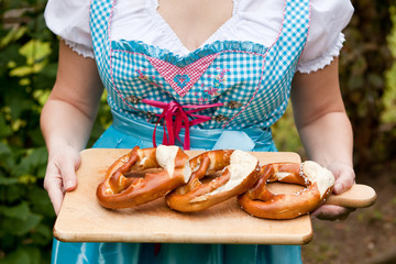 Wall Mural - Oktoberfest Pretzel on cutting board with dirndl on background