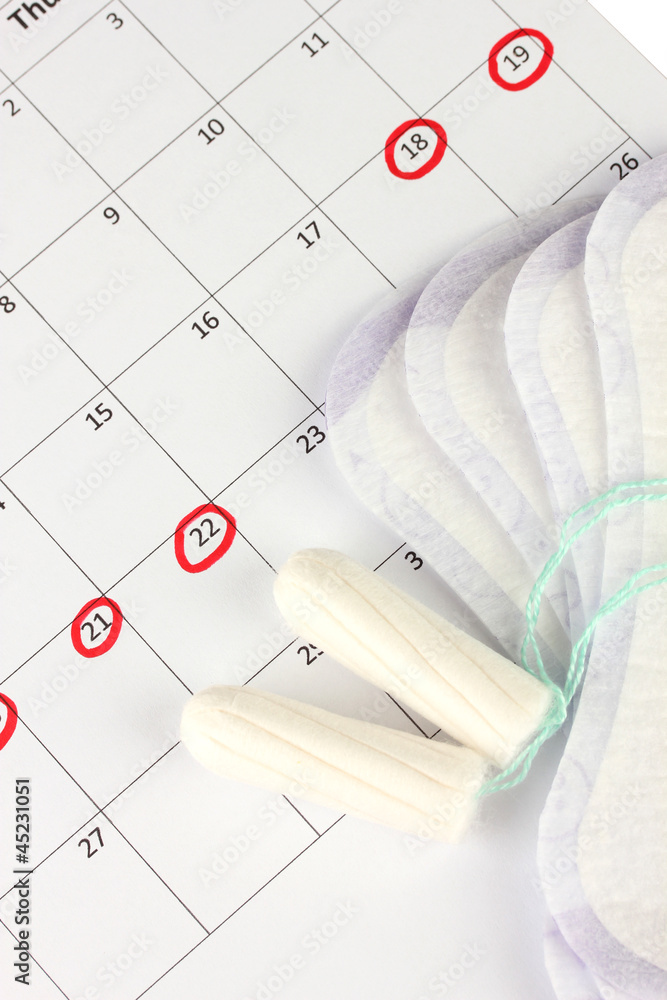 menstruation calendar with sanitary pads and tampons, close-up