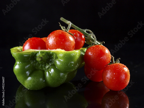 Board z aluminiowym obramowaniem Pół zielona papryka pełna pomidorków cherry.