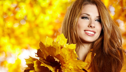 Sticker - Beautiful elegant woman standing in a park in autumn