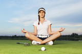 Fototapeta Desenie - Girl golfer sitting in yoga posture on golf course.