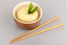 Asian Noodles In Bowl On Grey Mat