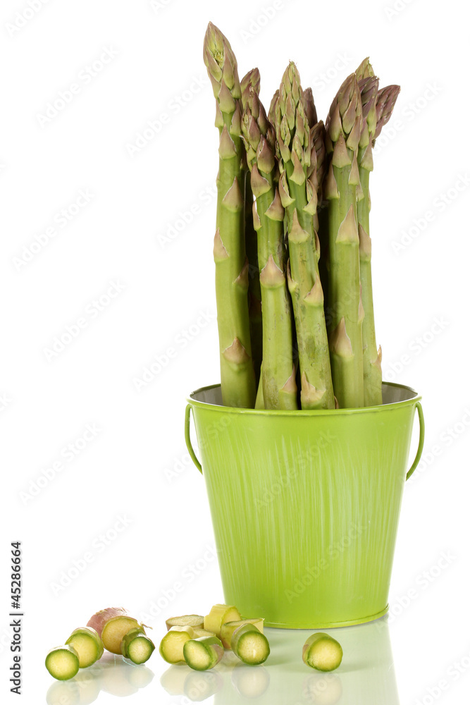 Fresh asparagus in green pail isolated on white.
