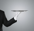 © rangizzz - Waiter holding empty silver tray over gray background