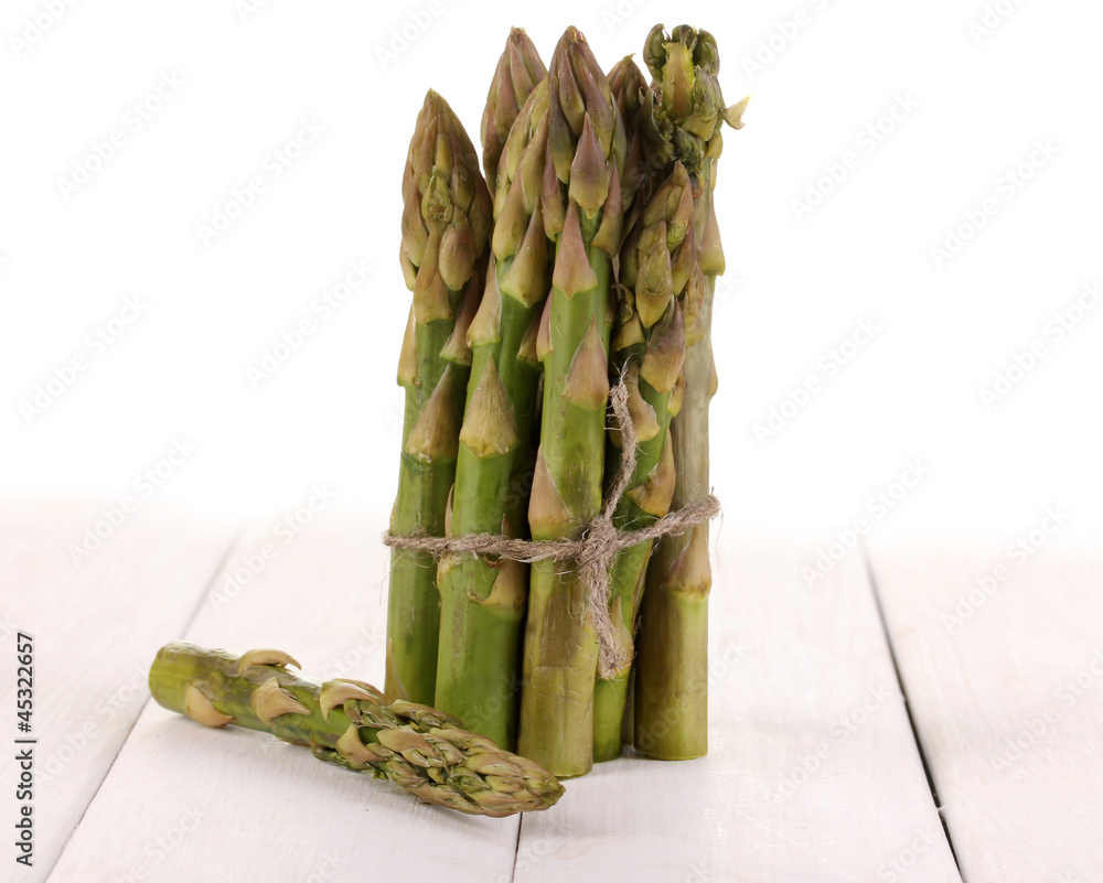 Useful asparagus on wooden table on white background