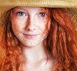 Beautiful freckled young woman wearing straw hat