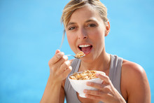 Healthy Woman Eating Bowl Of Cereals