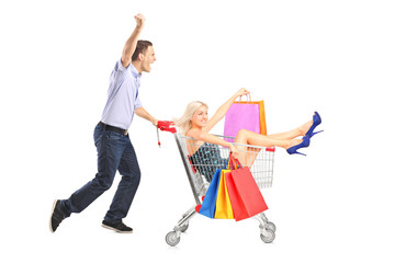 Canvas Print - Excited person pushing a shopping cart, happy woman with bags in