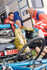 Wall Mural - Emergency paramedics helping woman bike accident