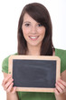 © auremar - woman holding a blackboard left blank for a message